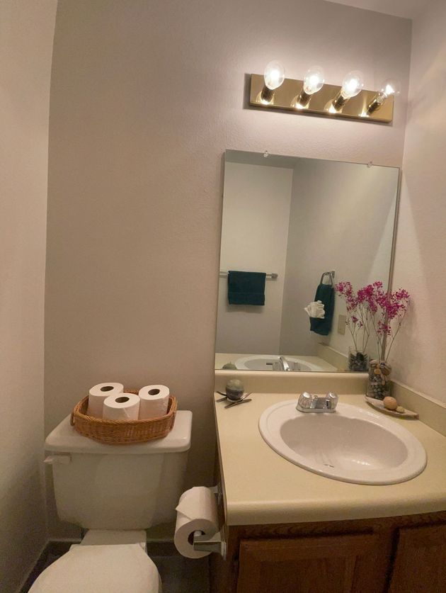 A bathroom with a toilet a sink and a mirror