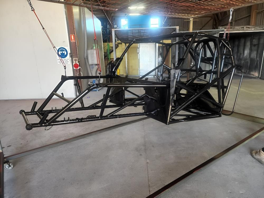 A Metal Frame Is Hanging From The Ceiling In A Warehouse — ADK Coatings In Toolooa, QLD