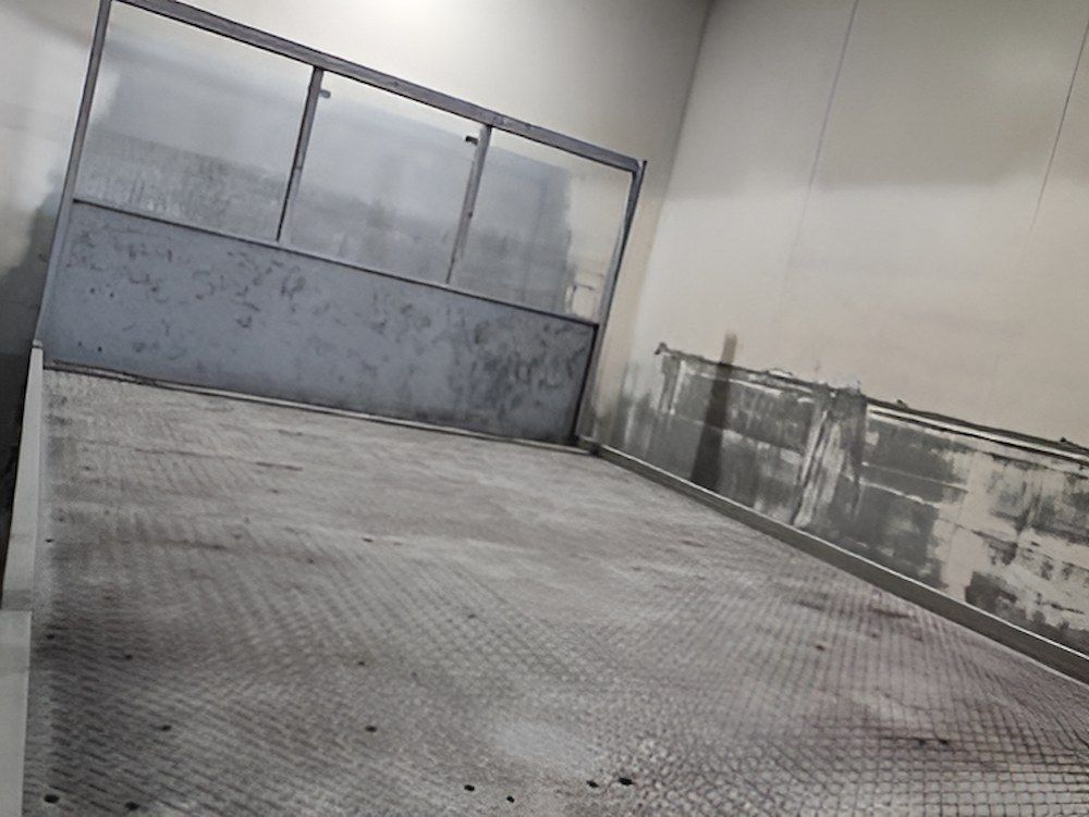 An Empty Warehouse With A Gray Wall And A Metal Floor — ADK Coatings In Toolooa, QLD