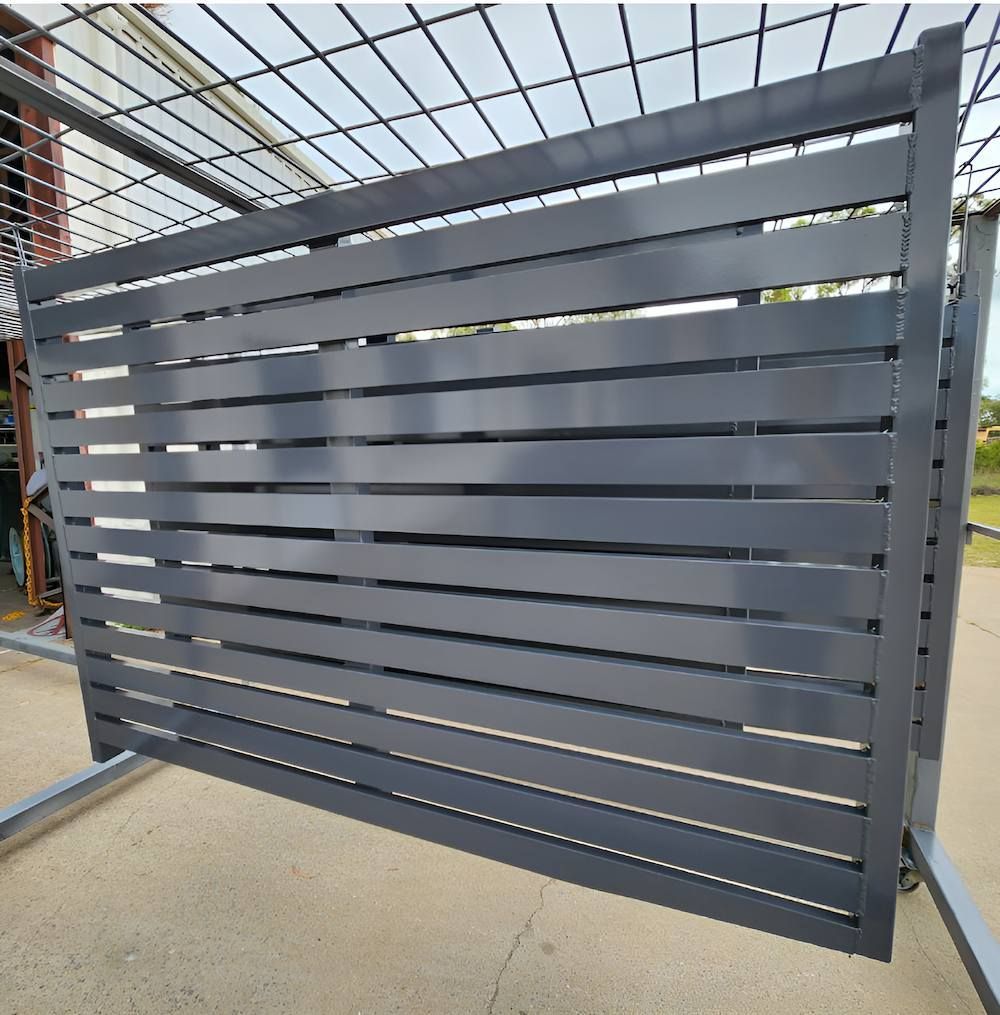 A Black Metal Fence Is Sitting On The Ground — ADK Coatings In Boyne Island, QLD
