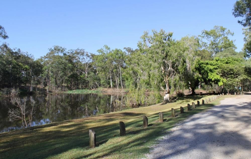 A Dirt Road Leading To A Lake Surrounded By Trees — ADK Coatings In Boyne Island, QLD