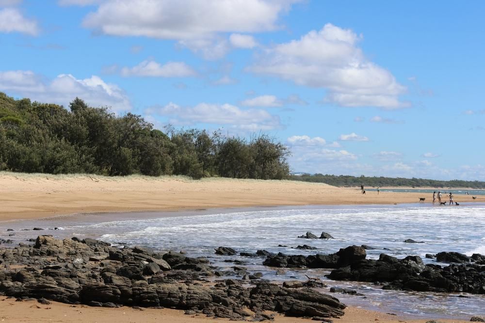 A Beach With A Lot Of Rocks And Trees In The Background — ADK Coatings In Tannum Sands, QLD