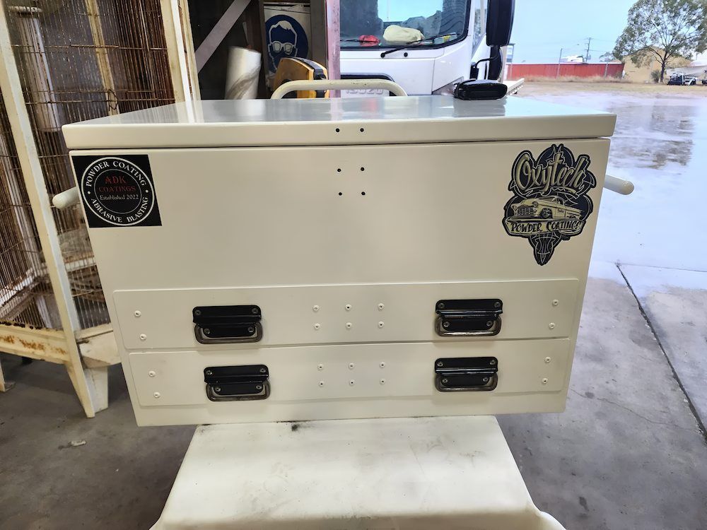 A White Toolbox With Black Handles Is Sitting On Top Of A White Table — ADK Coatings In Toolooa, QLD