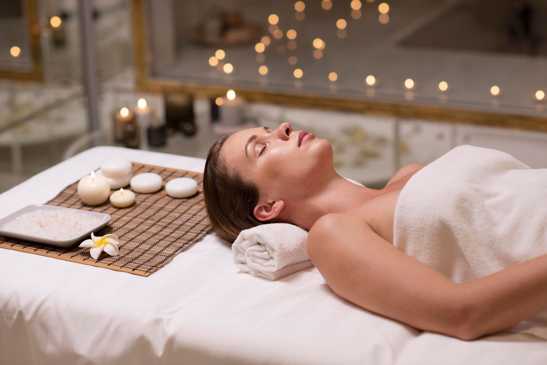 a woman is laying on a massage table with her eyes closed
