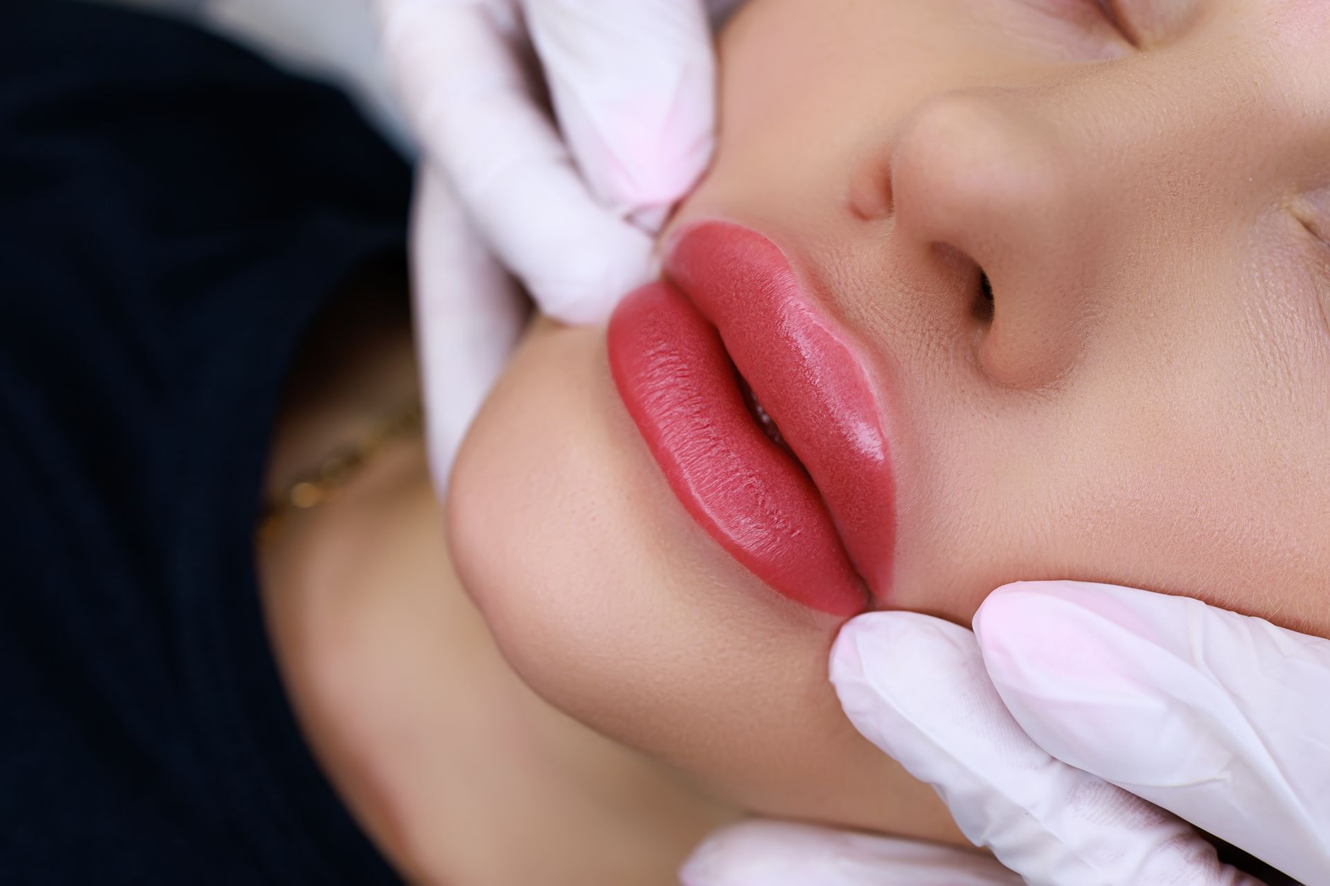 a woman is getting permanent makeup on her lips .