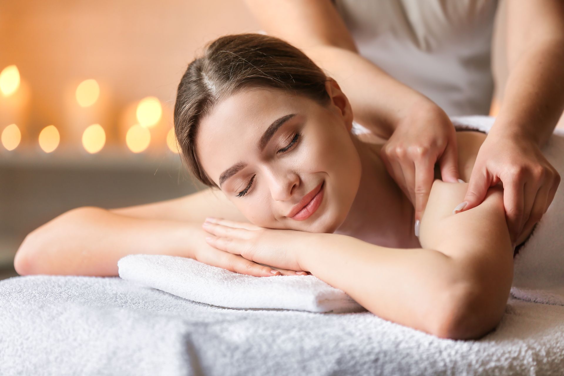 a woman is smiling while getting a massage at a spa