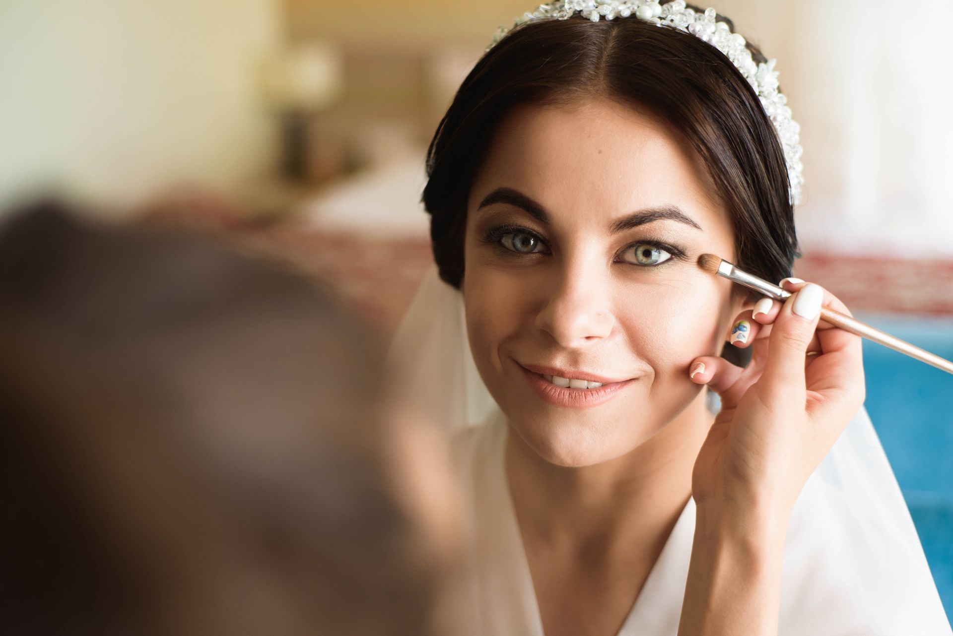 a bride is getting her makeup done in front of a mirror .