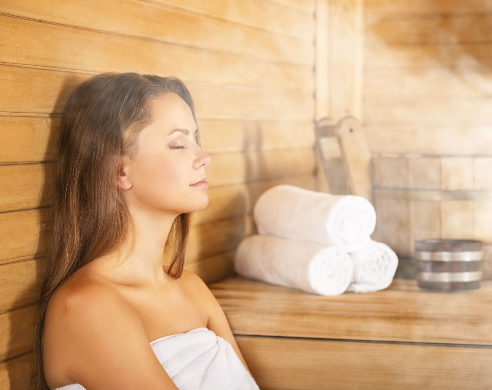 a woman sitting in a sauna with her eyes closed