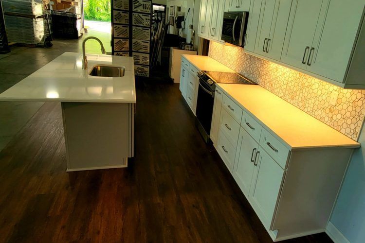 a kitchen with black cabinets and stainless steel appliances