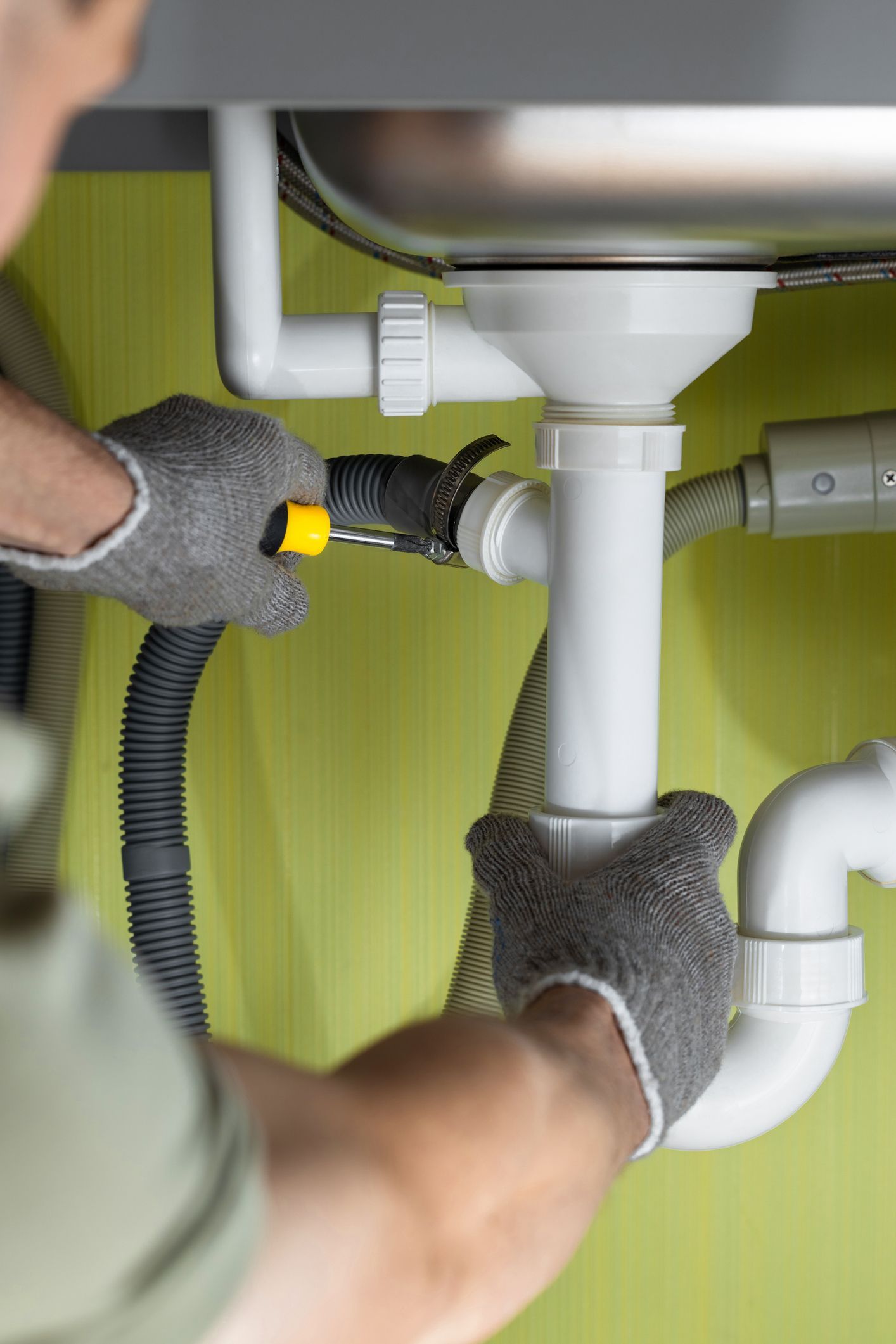 Repairing a pipe in the kitchen under the sink.] 