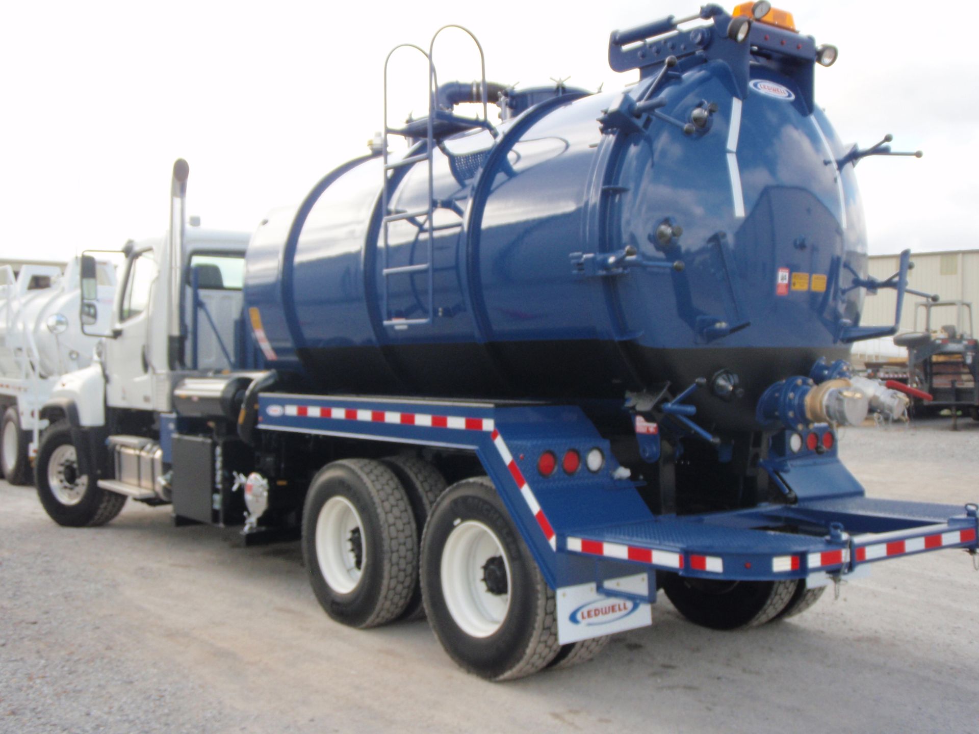 Blue vacuum truck parked outdoors.