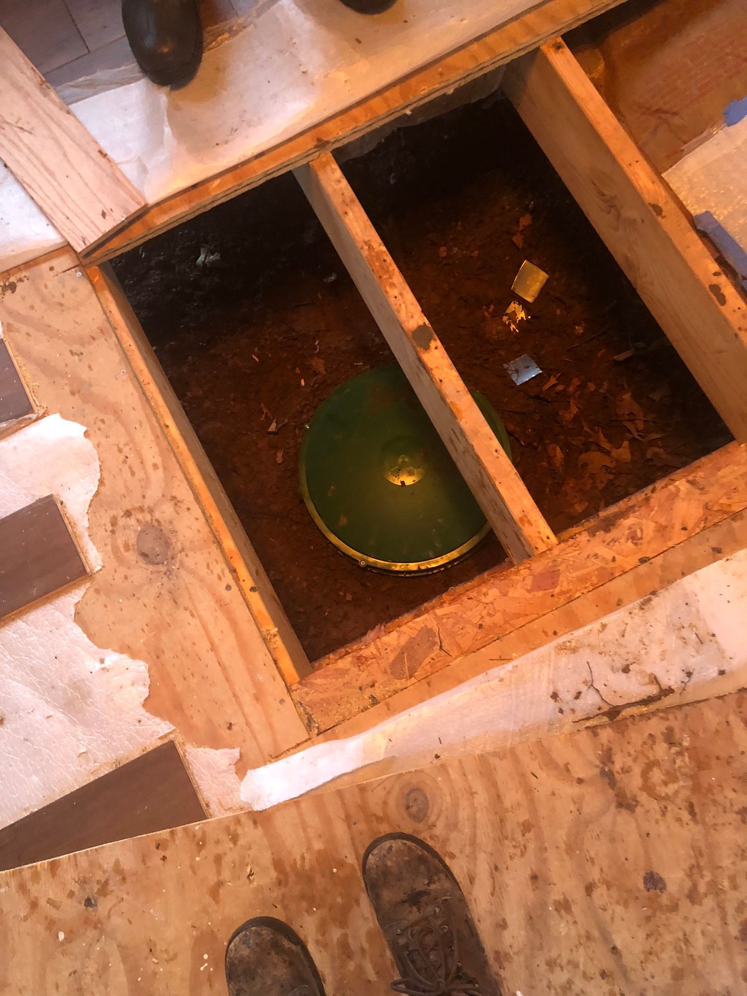 Open floor, wooden frame, green plumbing fixture visible.
