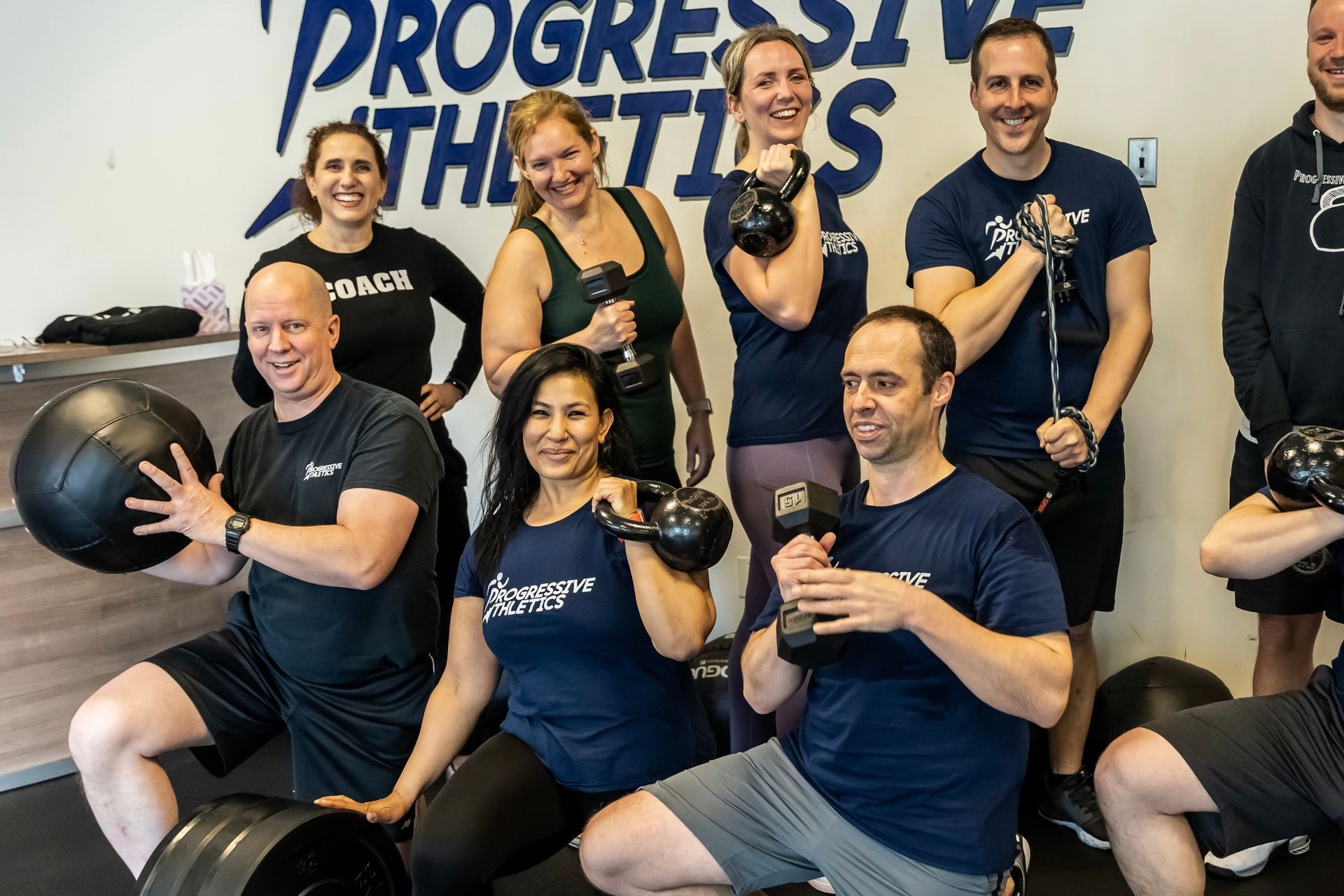 A group of people are posing for a picture in a gym.