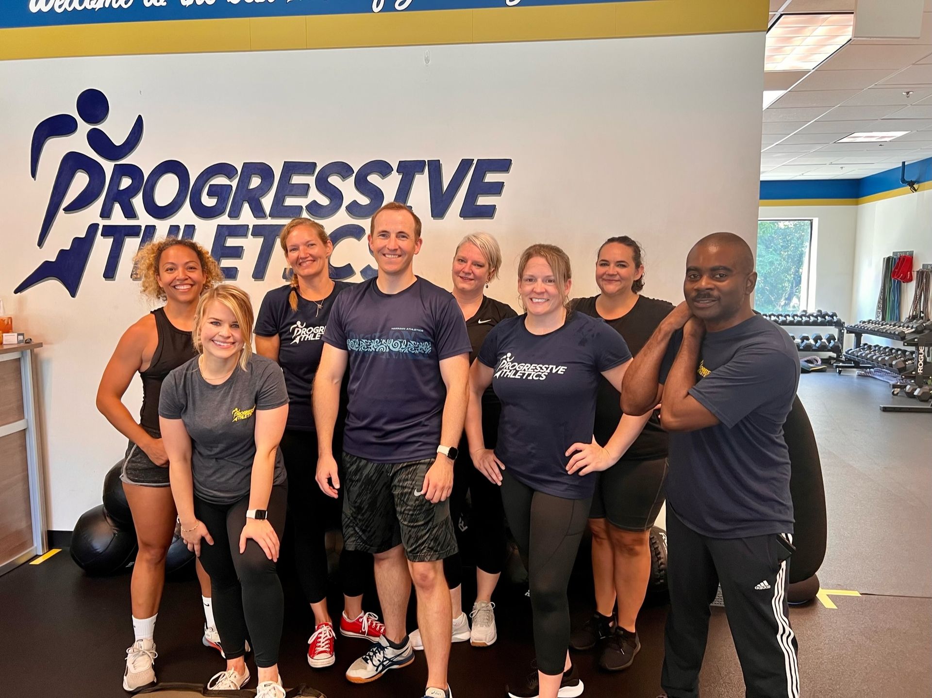 A group of people are posing for a picture in a gym.