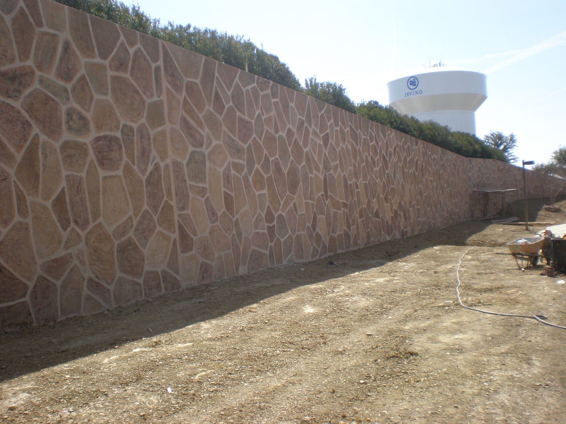 Stone facade wall with a water tower in the background.