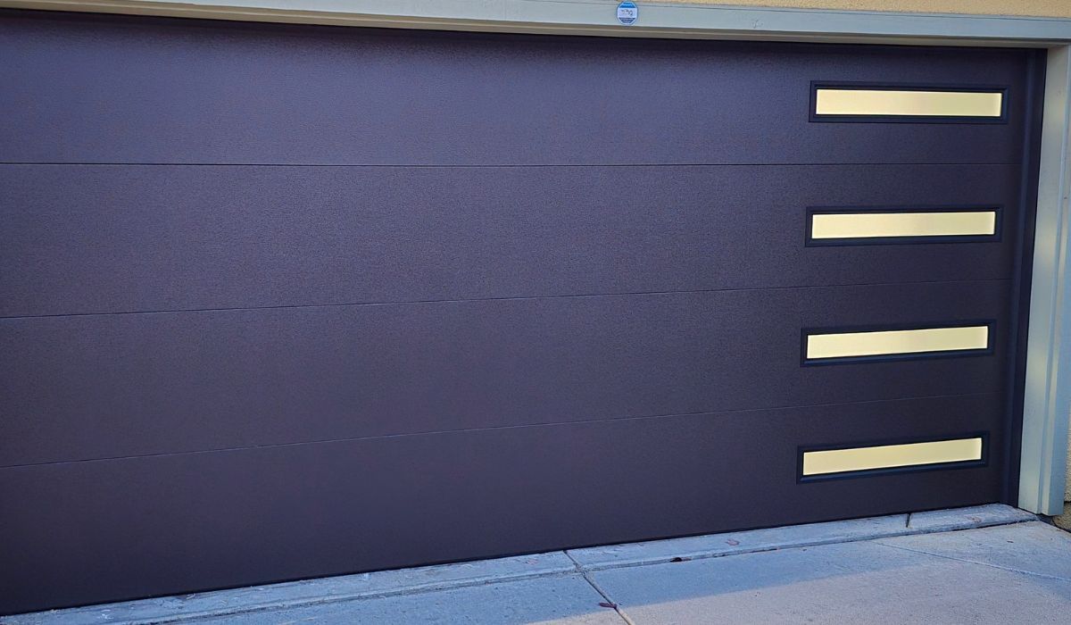 Closed dark blue garage door with three horizontal beige accents on the right side