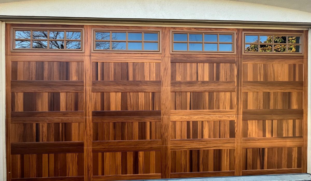 Wooden garage doors with small stained-glass windows along the top row