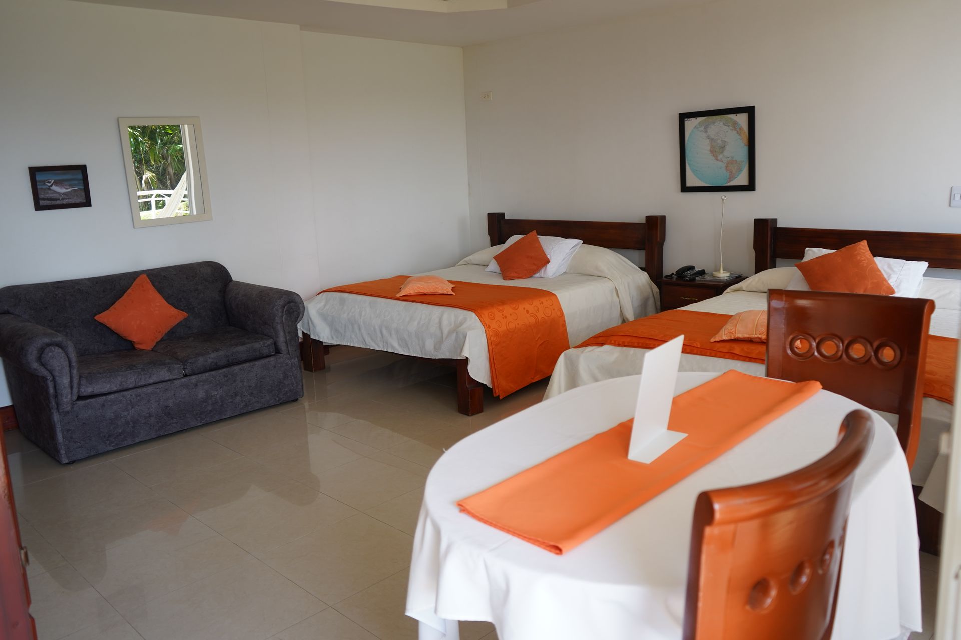 Una habitación de hotel con dos camas, un sofá y una mesa.