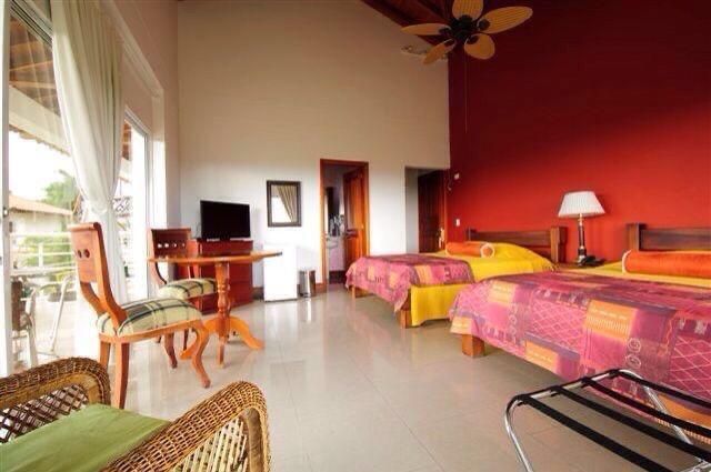 Una habitación de hotel con dos camas y un ventilador de techo.