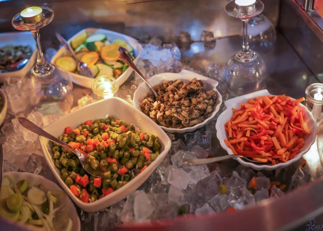 Una variedad de verduras están colocadas sobre hielo sobre una mesa.