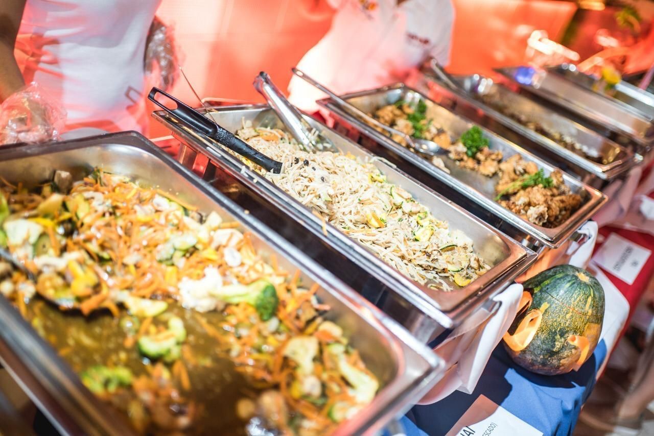 Una línea de buffet llena de muchos tipos diferentes de comida.