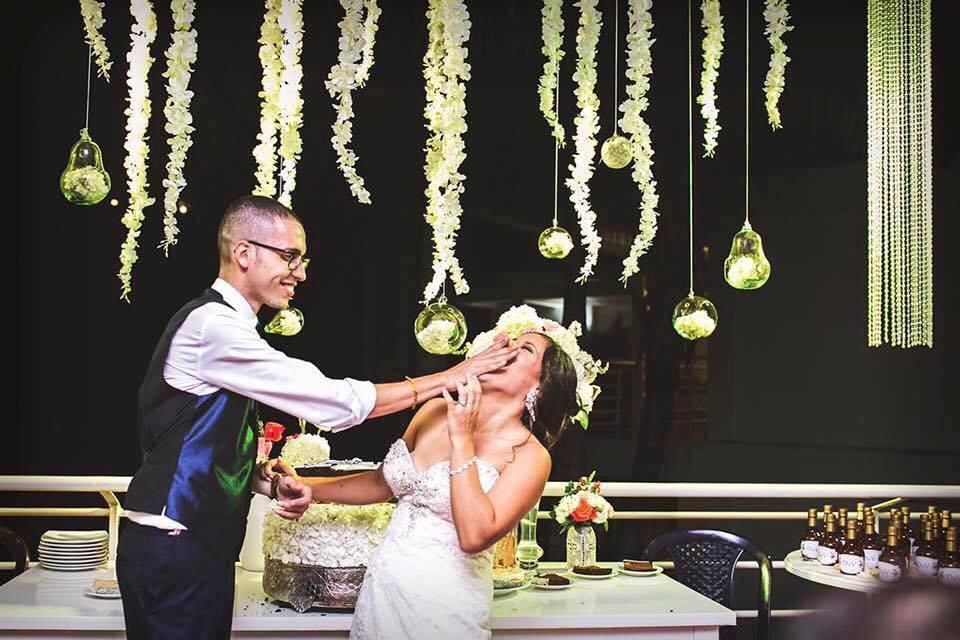 Una novia y un novio están cortando juntos su pastel de bodas.