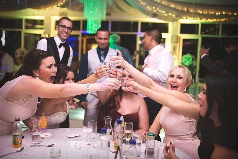 Un grupo de personas están brindando entre sí en una recepción de boda.