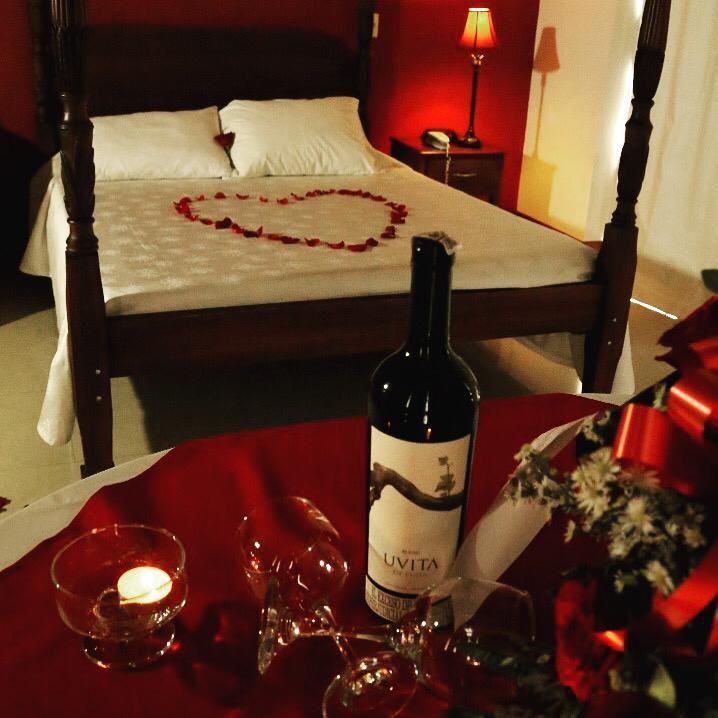 Una botella de vino Livita reposa sobre una mesa frente a una cama.