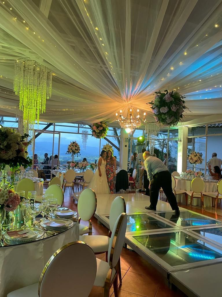 Una novia y un novio están de pie en una pista de baile en una recepción de boda.