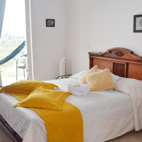 Una cama con almohadas amarillas y una manta amarilla.