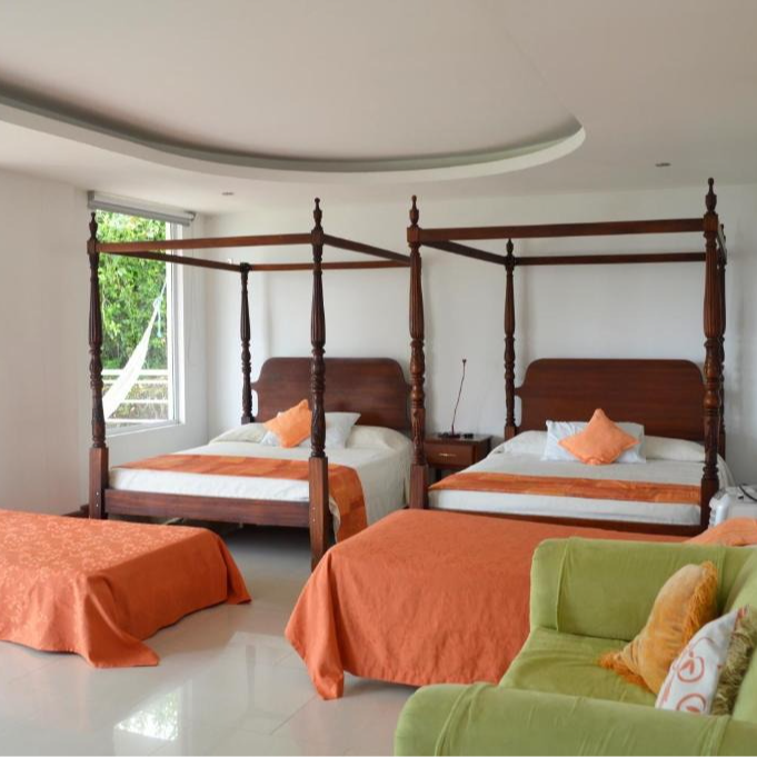 Un dormitorio con cuatro camas con dosel y una silla verde.