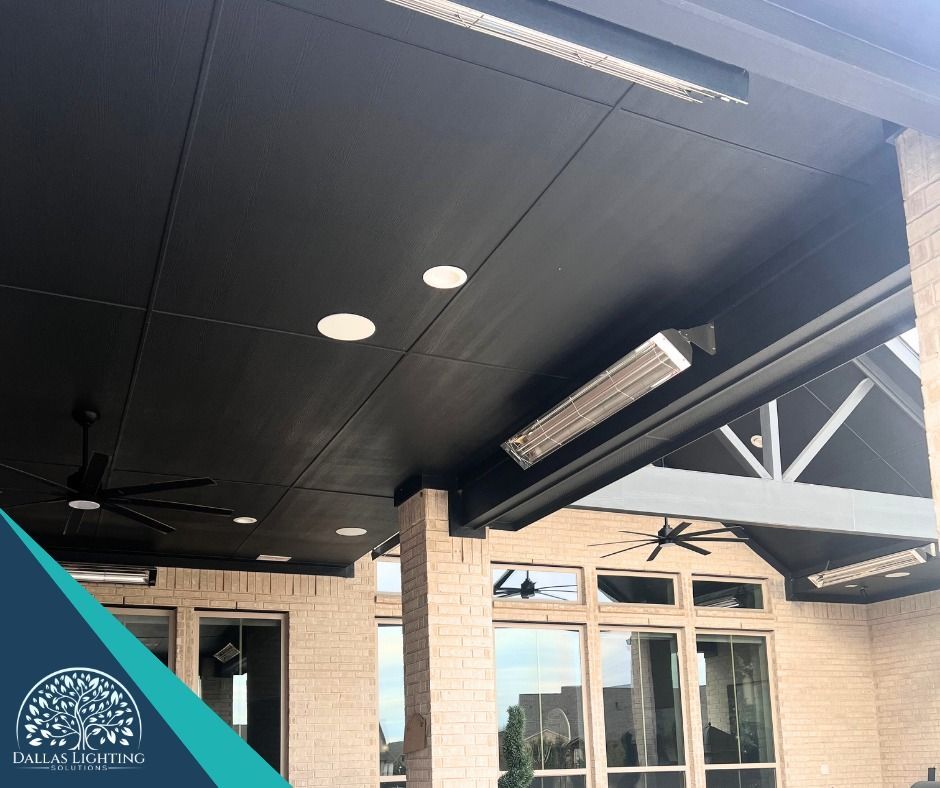 A patio with a black ceiling and a ceiling fan.