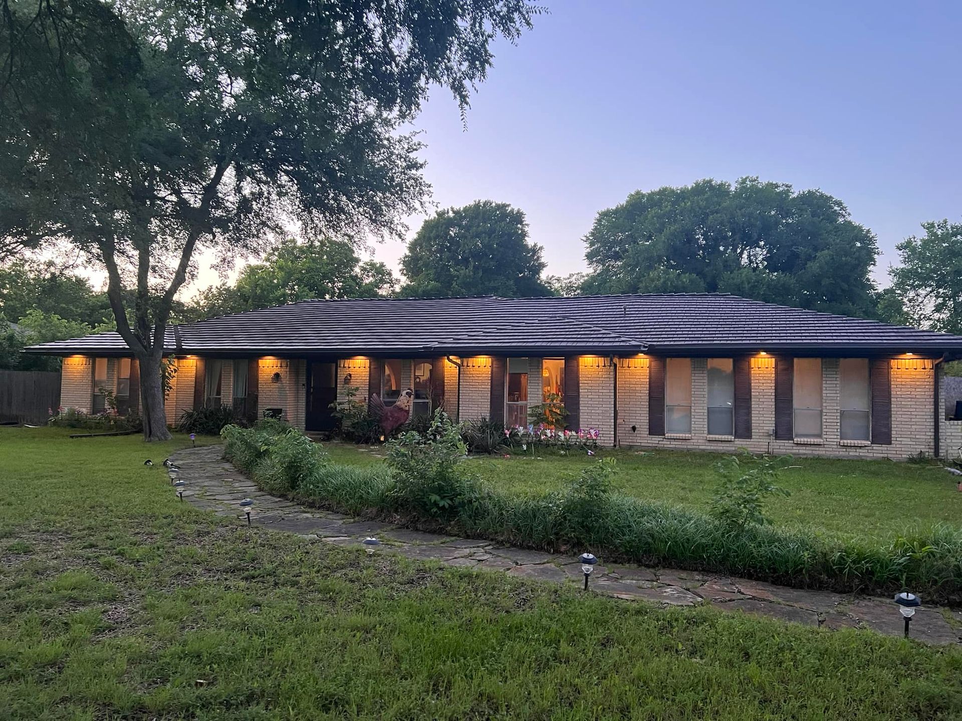 A large house with a lot of windows is lit up at night