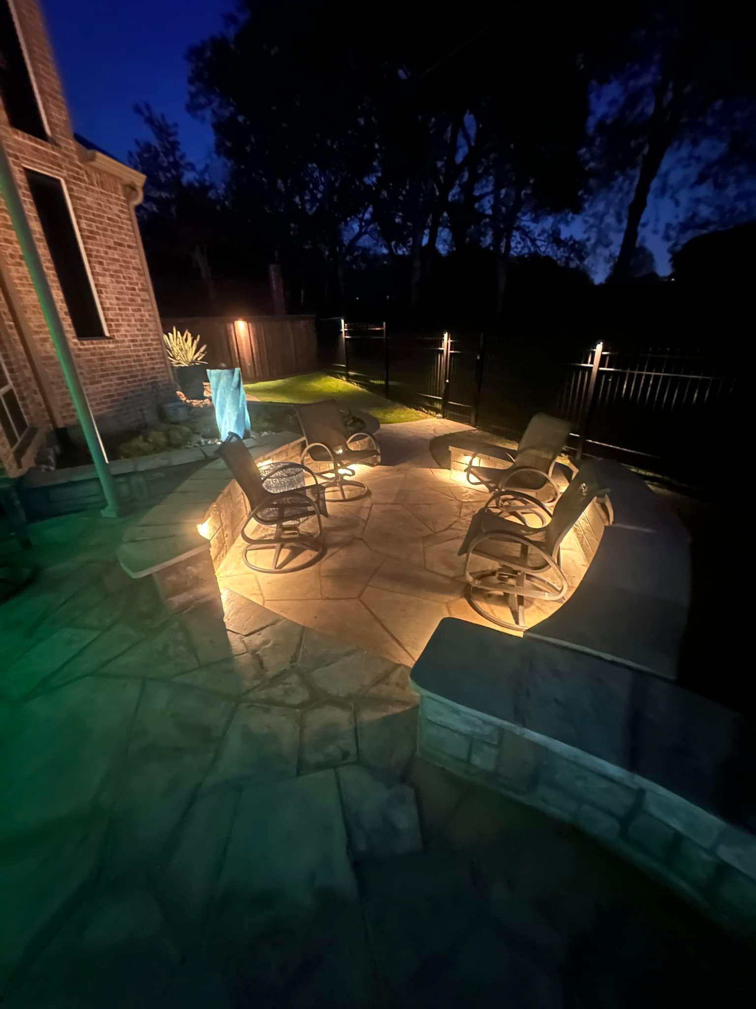 A patio with tables and chairs is lit up at night.