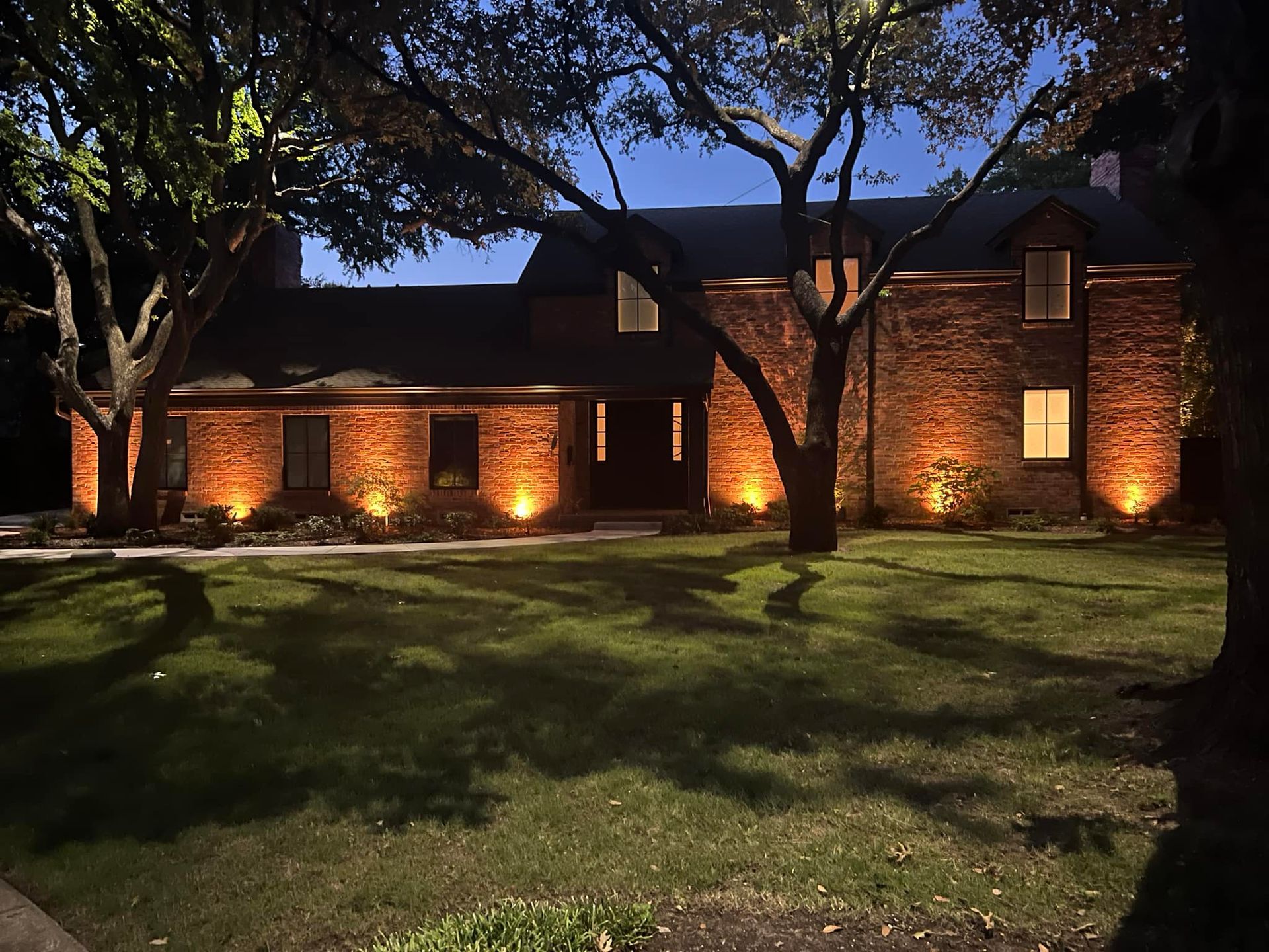 A large brick house is lit up at night