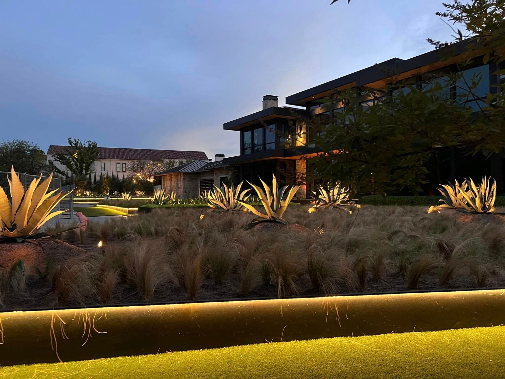 A large house with a lot of plants in front of it