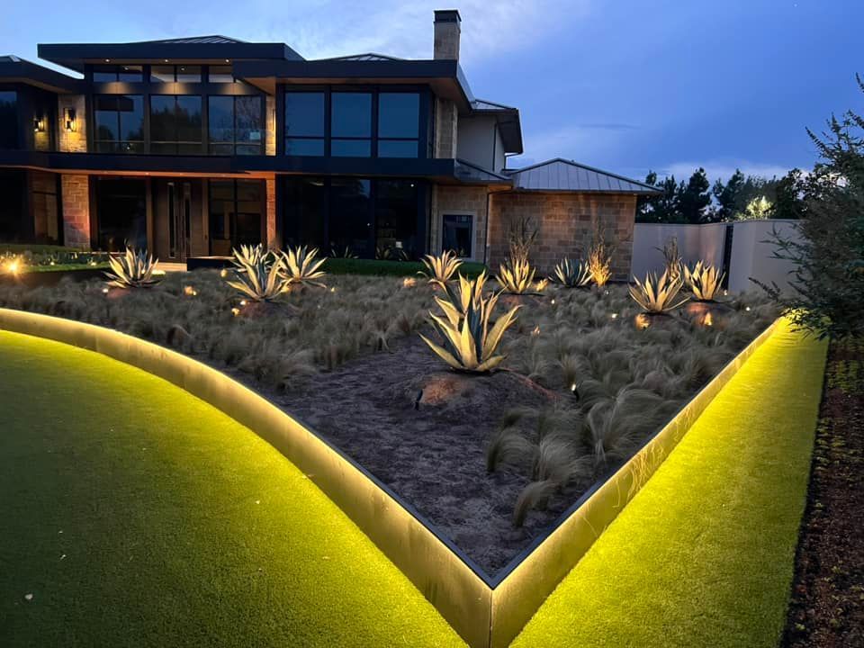 A large house with a lot of windows is surrounded by a lush green lawn.