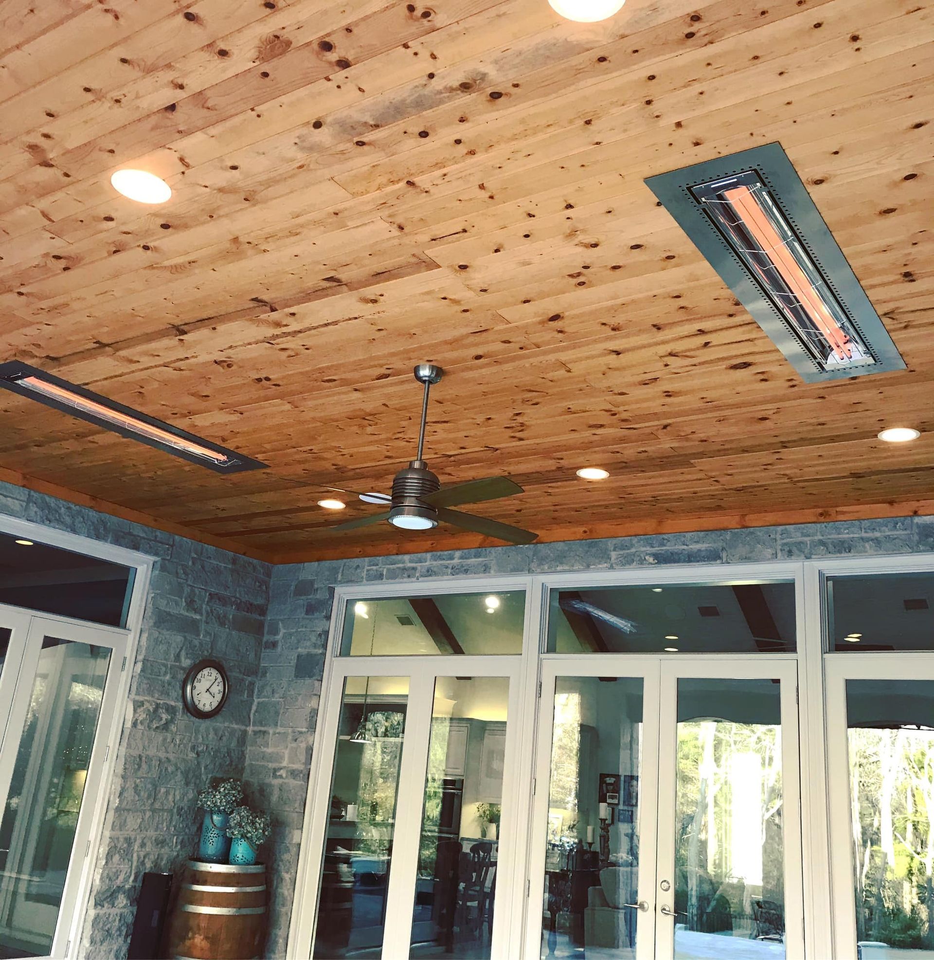 A room with a wooden ceiling and a ceiling fan