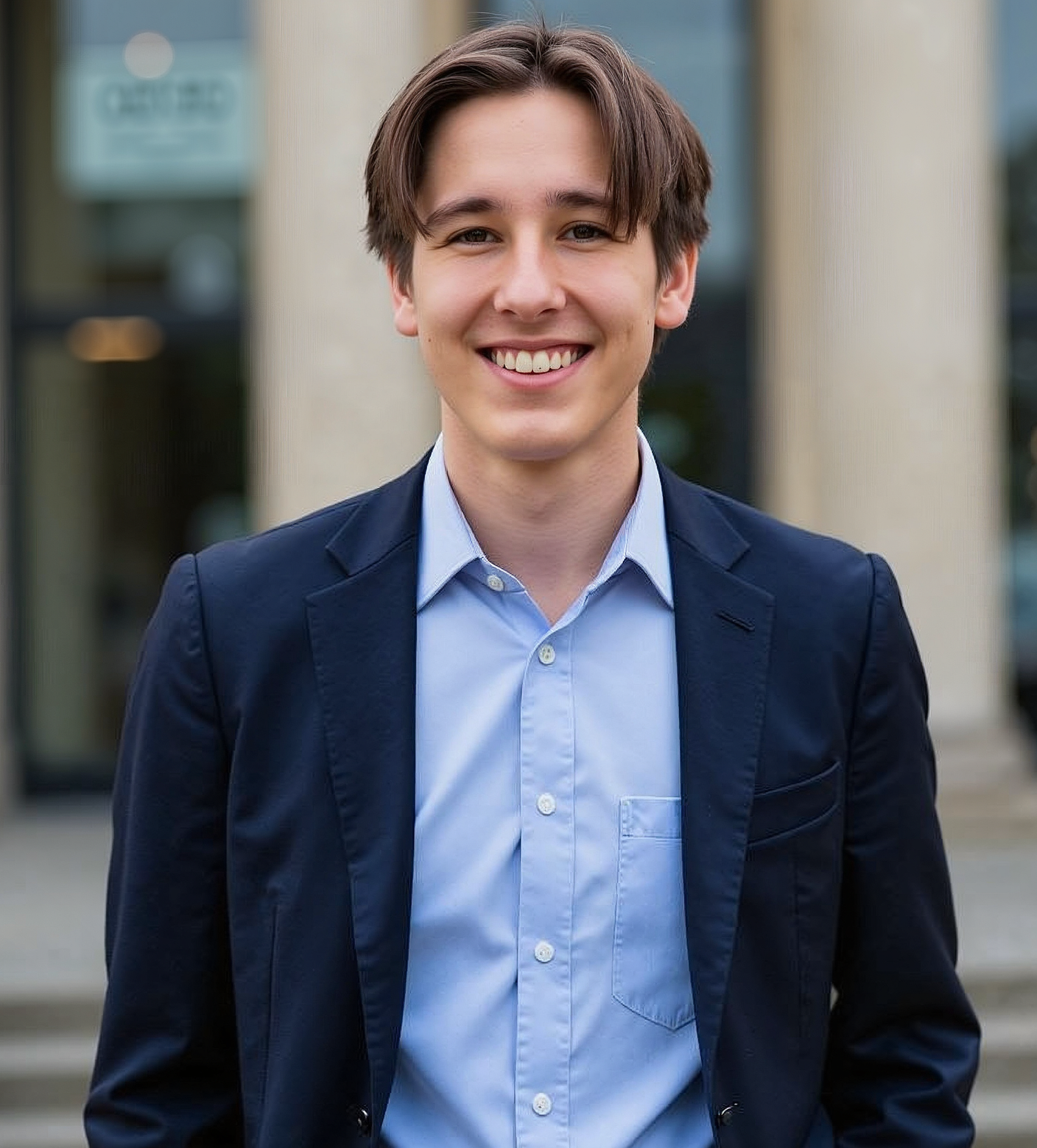 A woman in a brown sweater is smiling for the camera.