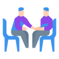 Two men are sitting at a table shaking hands.