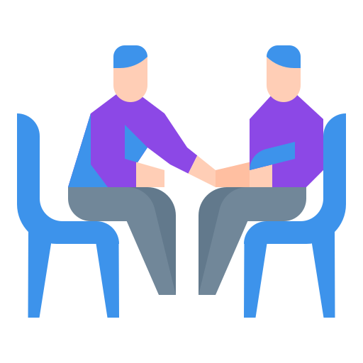 Two men are sitting at a table shaking hands.