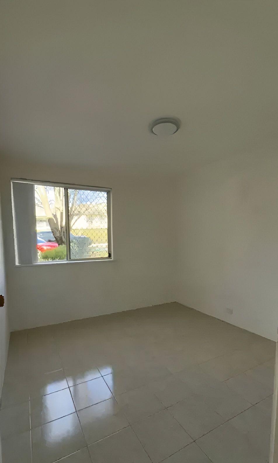 Empty Room With Square Tile Floors, Window, and Overhead Light — Cleanaroo Services in Conder, ACT