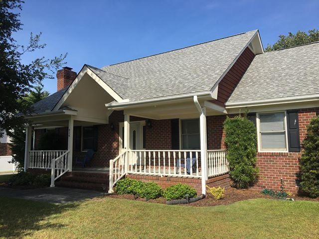 A brick house with a porch and a white railing