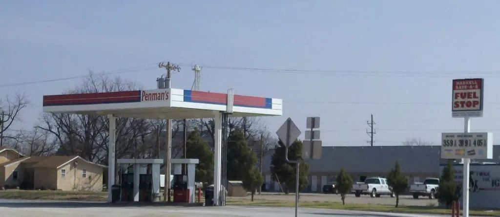 Gas station under a blue sky. A sign reads 