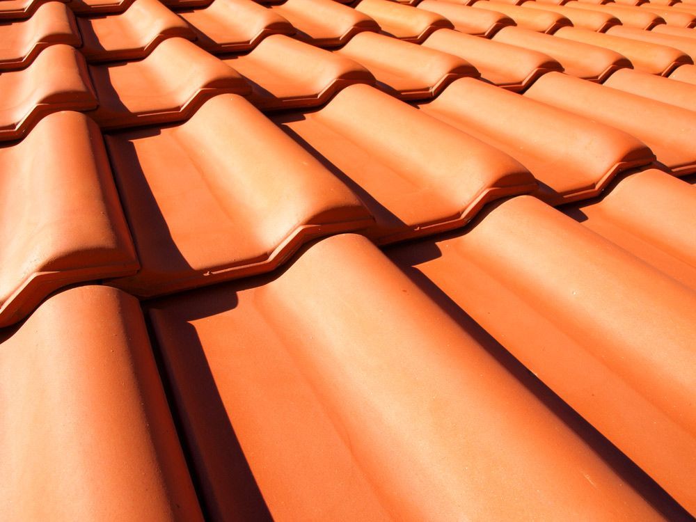 A Close Up Of A Row Of Orange Tiles On A Roof — Topflite Roofing In Vincentia, NSW
