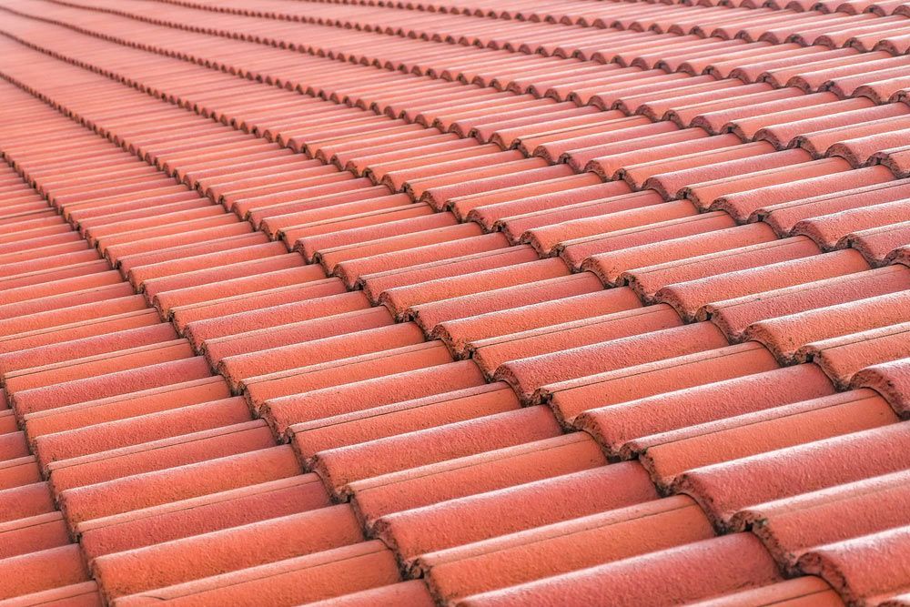 A Close Up Of A Row Of Red Tiles On A Roof — Topflite Roofing In Vincentia, NSW