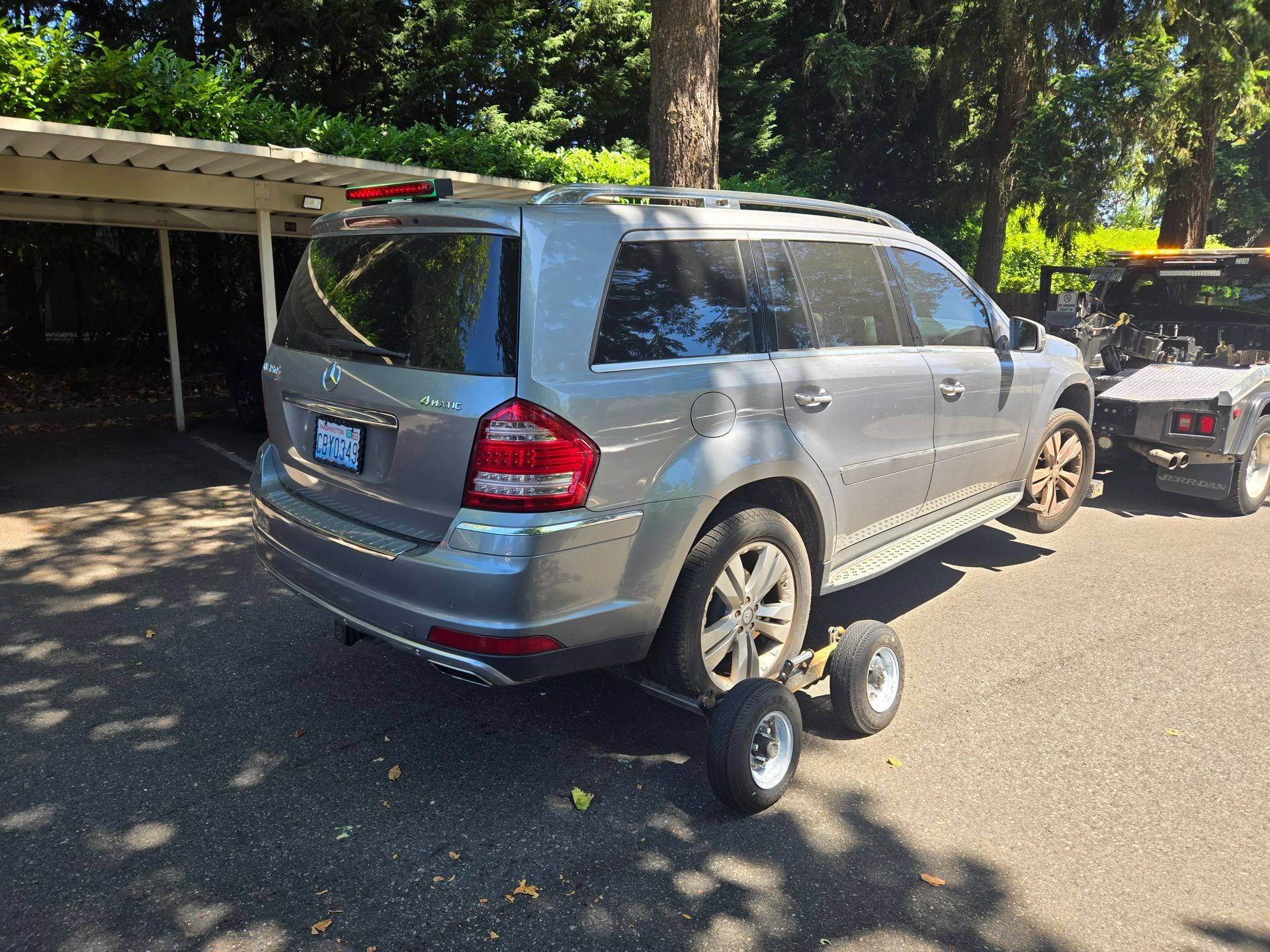 A silver suv is being towed by a tow truck