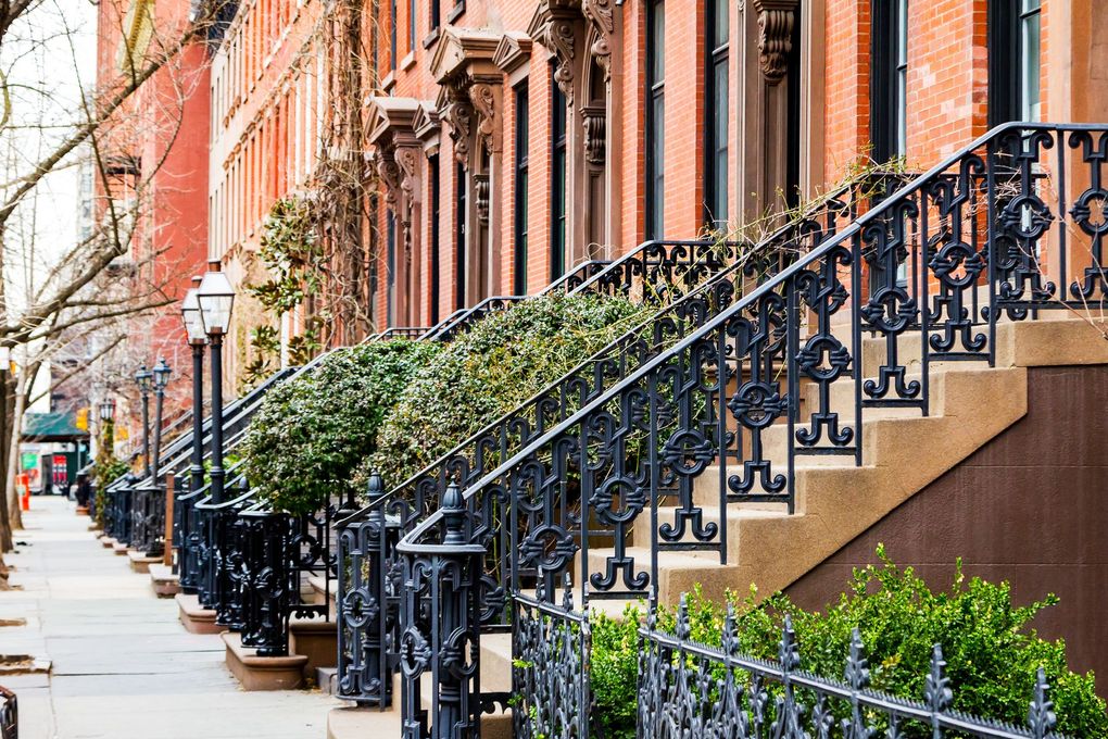 A row of brick buildings with stairs leading up to them.