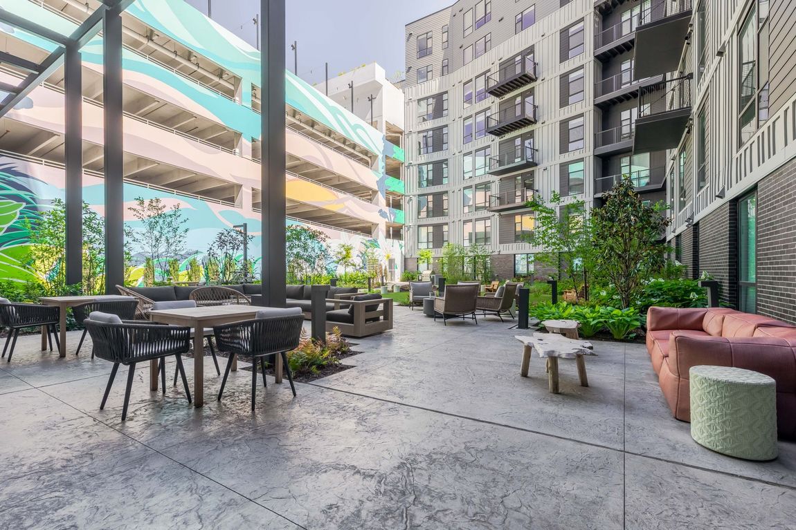 A courtyard with tables and chairs in front of a building.
