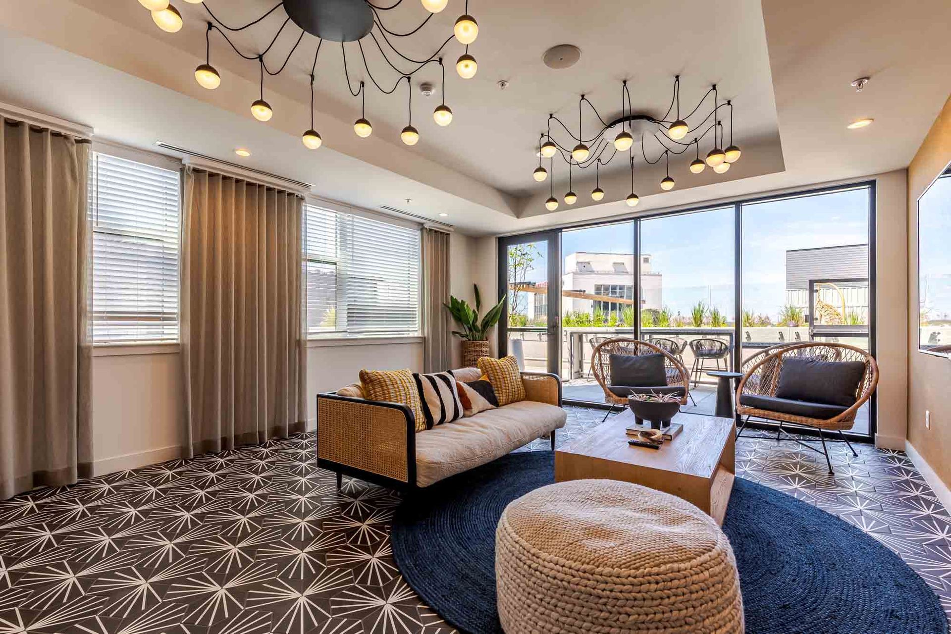 A living room with a couch , coffee table , chairs and ottomans.